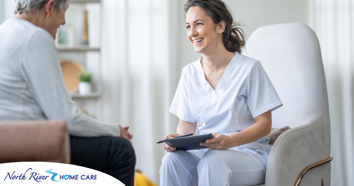 A woman smiles and enjoys her caregiving job as she writes notes down with a client.