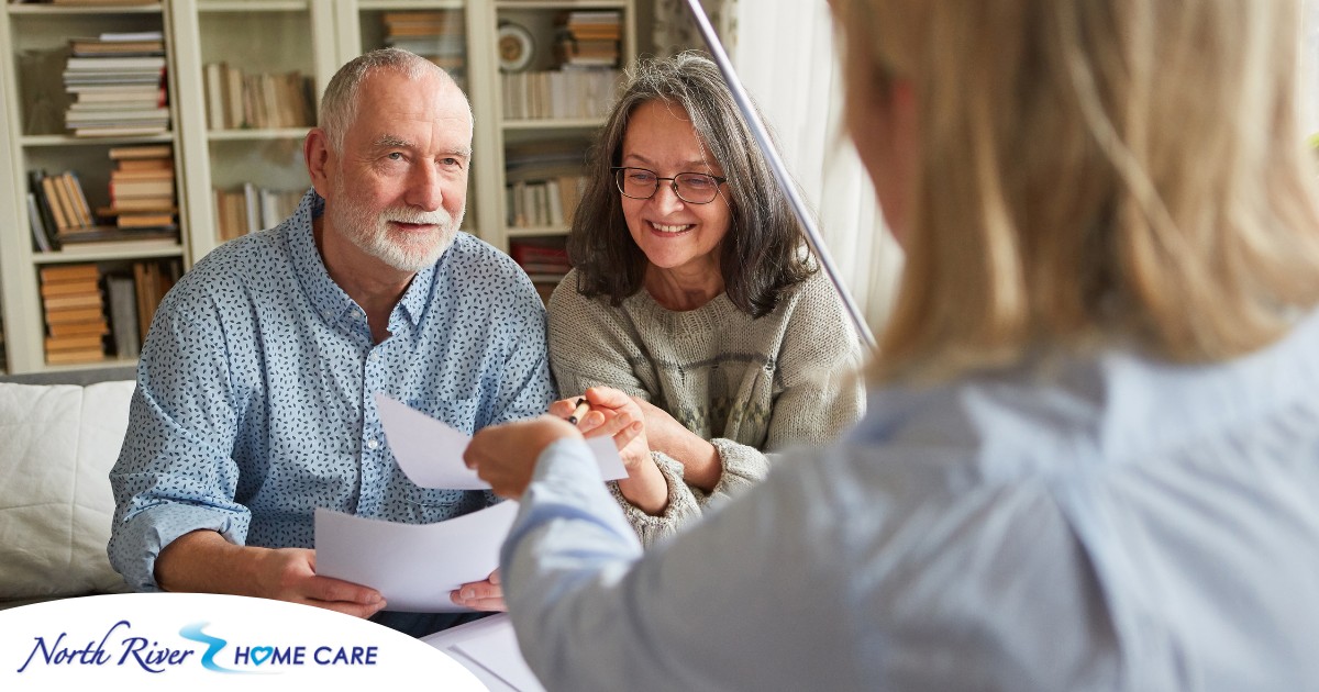 An older couple receives and considers papers from a woman, representing someone considering long-term care insurance.