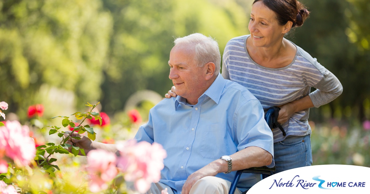 A caregiver takes a senior outside to visit a garden, highlighting one idea for senior activities.