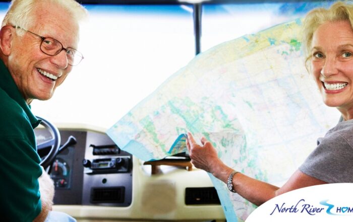 An older couple looks back smiling from the front of an RV, representing how day trips for seniors can help boost the mood of everyone.