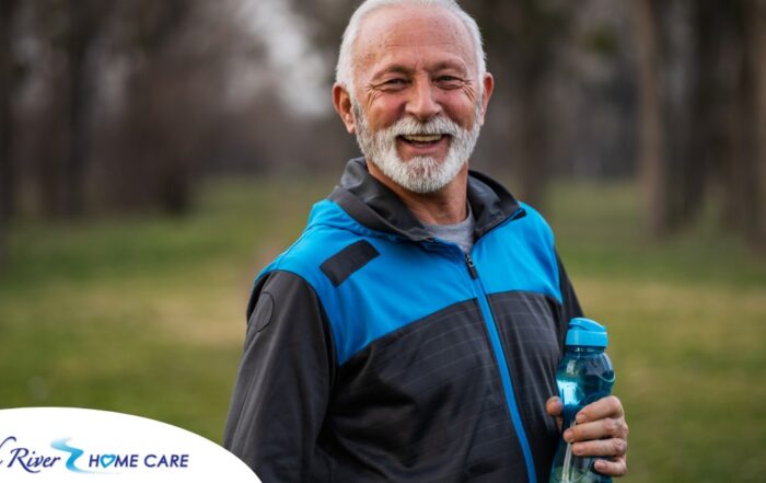 An older man smiles with a water bottle while exercising, representing the benefits of encouraging exercise when caring for seniors at home.