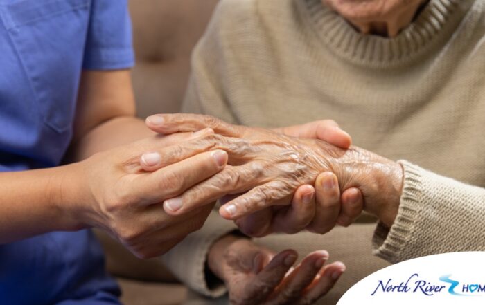 A care provider examines an older adult’s fingers, representing what would happen in an examination for rheumatoid arthritis.