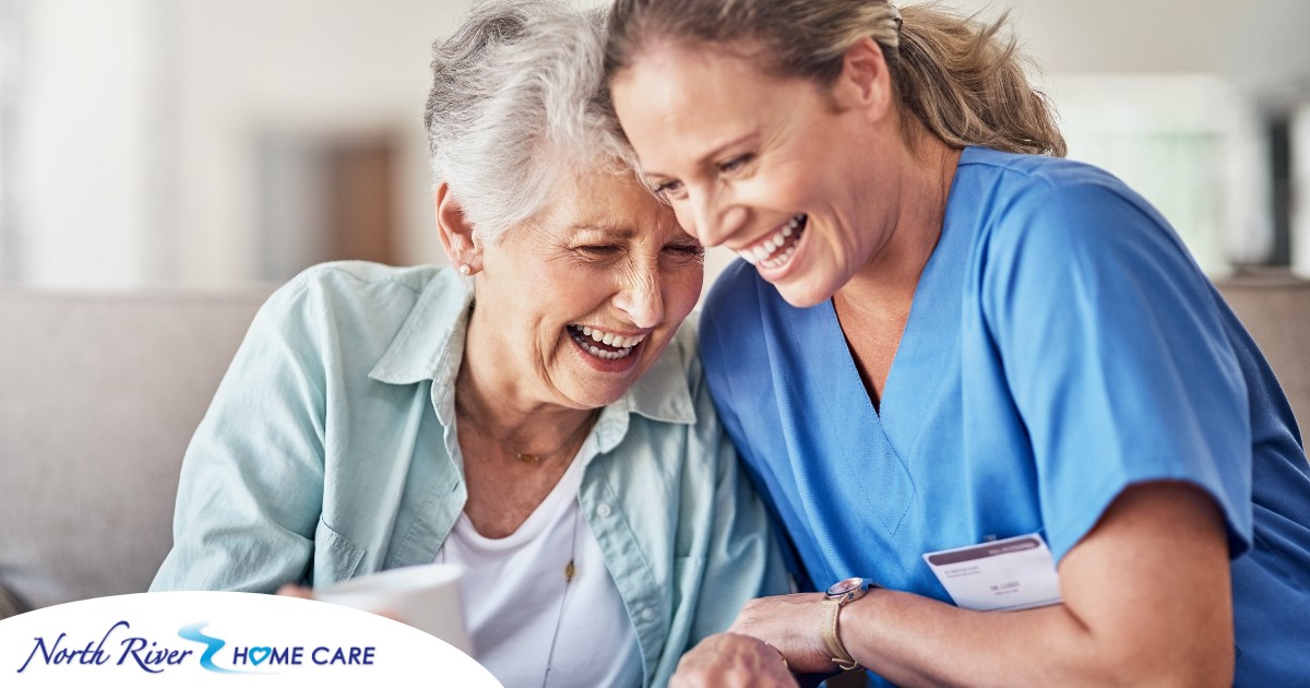 A woman in scrubs laughs with a senior woman, representing how caregiving can be a great career choice.